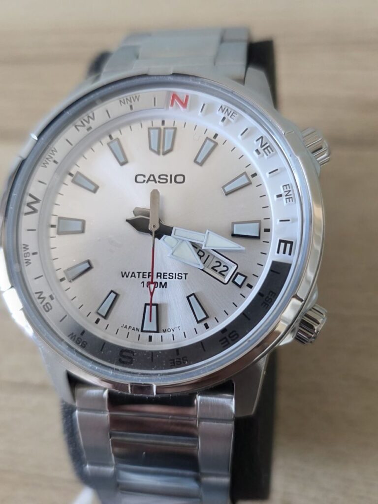 Casio MTD-130D-7A dial shot, showing silver dial, red second hand and compass bezel.