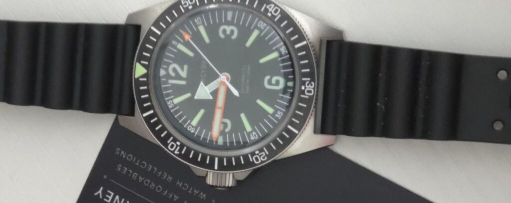 Phorcydes PH-4B skin diver watch with black dial, 3D lume blocks, orange minute hand, and black wave rubber strap.