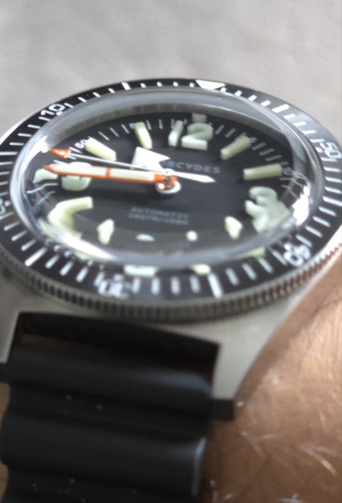 The Phorcydes PH-4B watch viewed from the side, emphasizing the slim 316L stainless steel mid-case and textured unidirectional ceramic bezel.