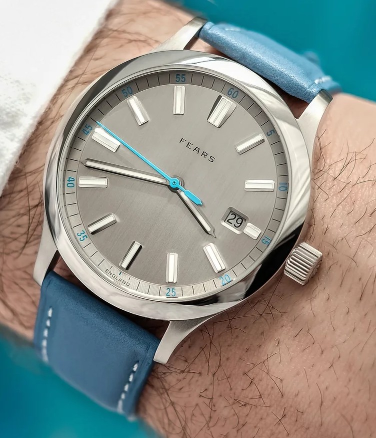 Fears Close-up wrist shot of a Fears Redcliff wristwatch featuring a brushed grey dial with light blue seconds hand, date window at 4 o'clock, and light blue leather strap