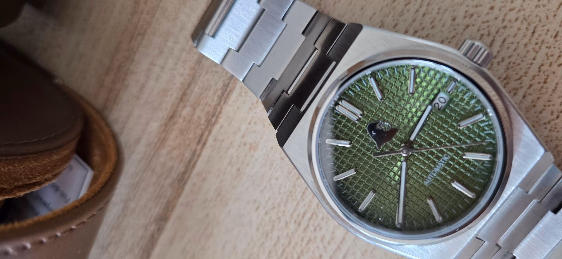 Review: Silverback Watches Interceptor Close-up of the Silverback Interceptor’s sage green waffle-textured dial with silver baton indices and the polished gorilla head logo below 12 o’clock