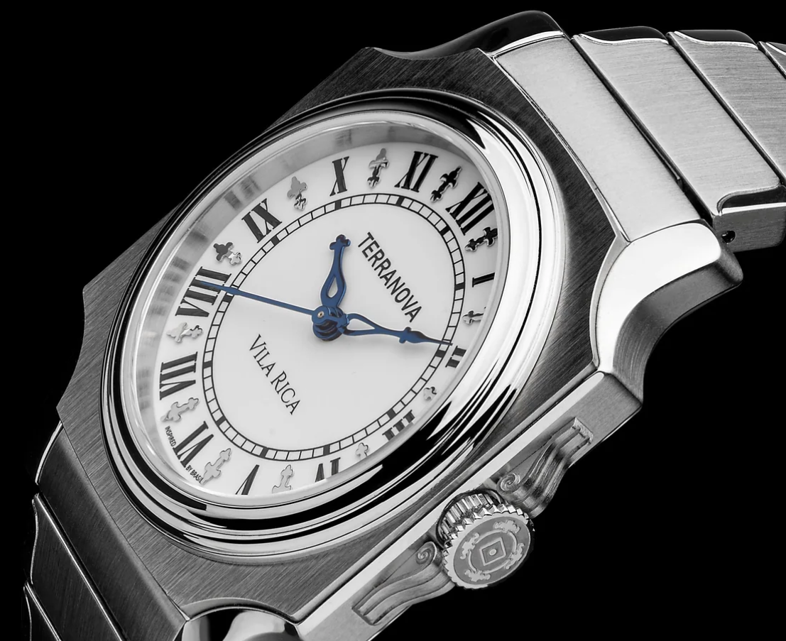 Terranova Watches Angled studio macro shot of the Terranova Vila Rica watch featuring a white dial, black Roman numerals, bluer hands, polished bezel, and integrated stainless steel bracelet.